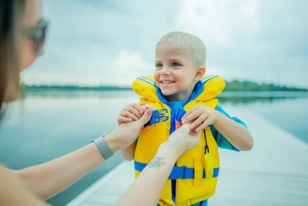 mom helping child put on life jacket